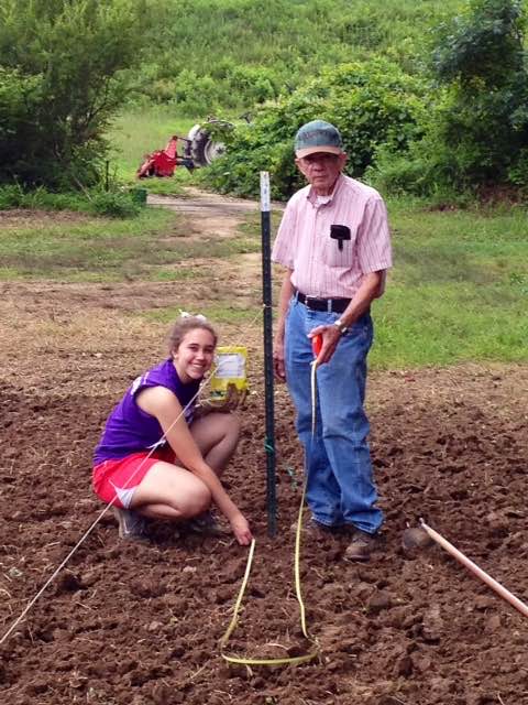 Breann Pritchett with her grandfather Marving Pritchett planting pumpkins
			   at the pumpkin patch